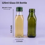 Product photo of a clear 125ml glass oil bottle with a green cap (filled as use example) standing next to an empty dark green glass bottle. Overlay text annotations show dimensions: Mouth 1 inch, Height 3.2 Inch, Base 1.5 Inch, against a light lavender background