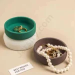 A person’s hand holding a shallow, lime green Nordic Round candle jar made from solid marble powder, featuring a wide circular design and a lit candle flame graphic. jarsify